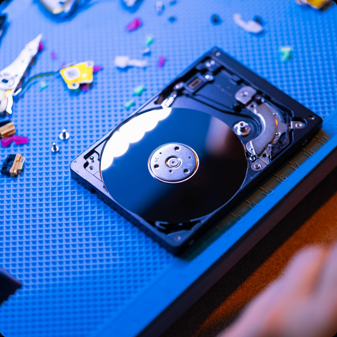 Disassembled hard drive on technician's workbench