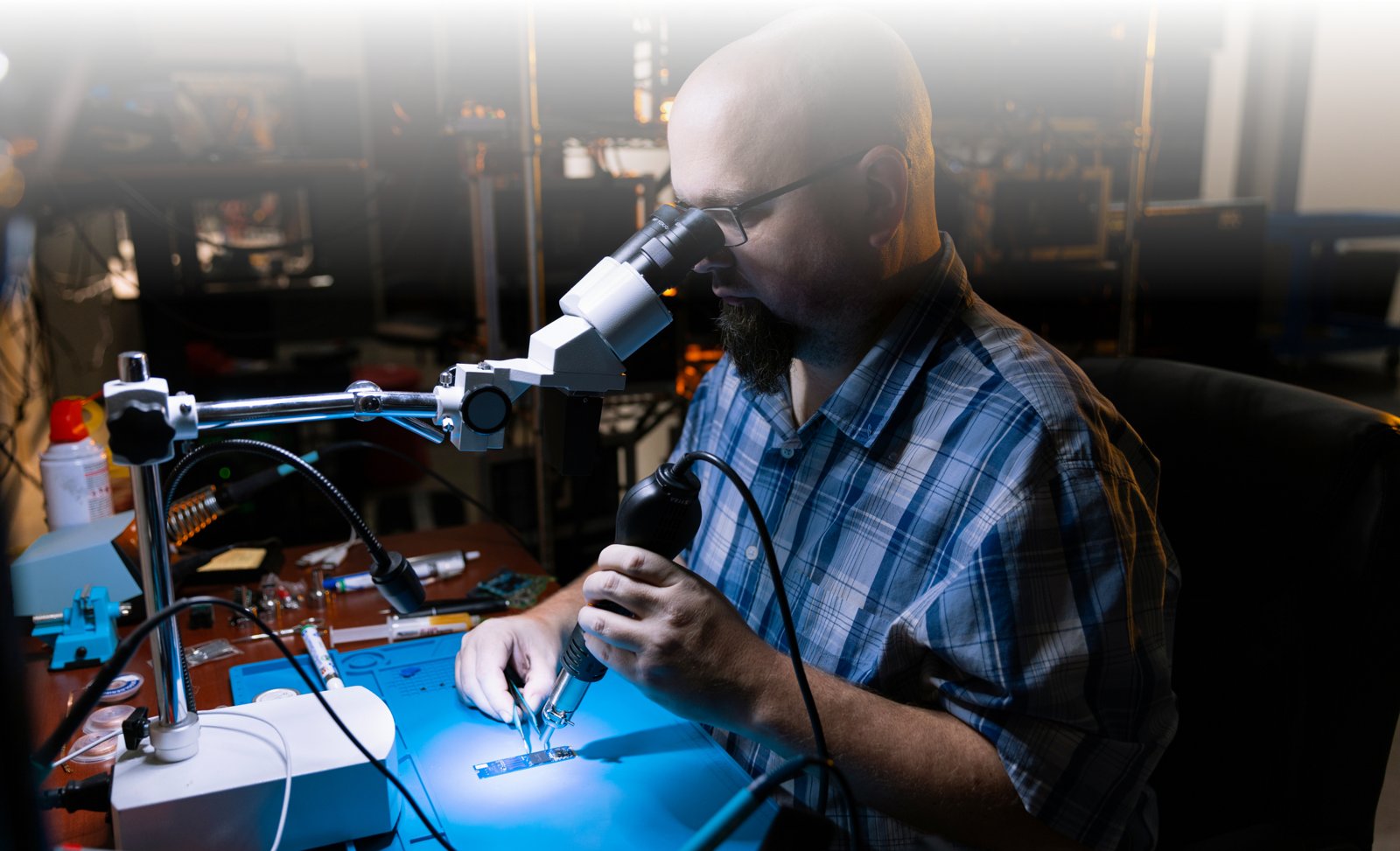 ATP technician examining a drive under a microscope